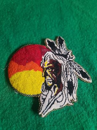 Two-part figural beaded plaque — profile head in warbonnet over graduated sun disk, plate 114